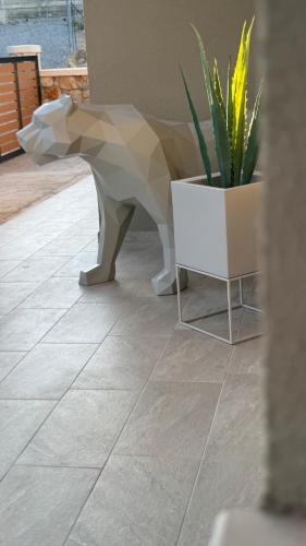 a ceramic dog statue next to a potted plant at ARYVE Boutique Villa mit Akropolis- und Meerblick, Infinity-Pool und Designer-Interieur in Malona Village