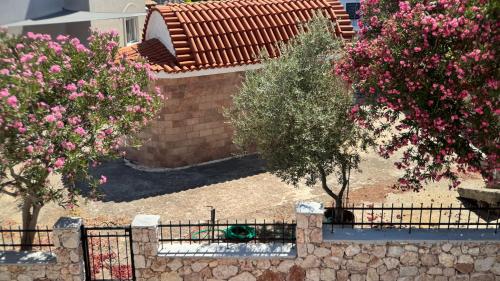 an aerial view of a house with trees and pink flowers at ARYVE Boutique Villa mit Akropolis- und Meerblick, Infinity-Pool und Designer-Interieur in Malona Village