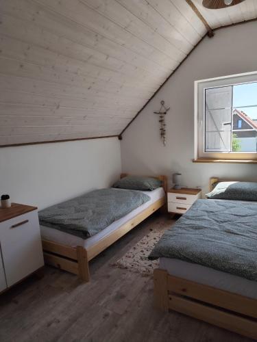 a bedroom with two beds and a window at Domki Letniskowe SZTORM in Jastrzębia Góra