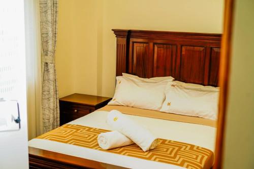 SyokimauにあるLuxore Rozina Airport View Apartment, Syokimau Nairobiの鏡にベッドが備わるベッドルームの反射