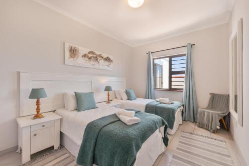 Un dormitorio con dos camas y una ventana. en Leander's Cottage, en Swakopmund