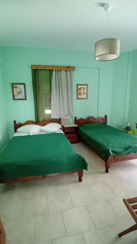 a bedroom with two beds with green sheets at Valta's Room 4 in Paleros