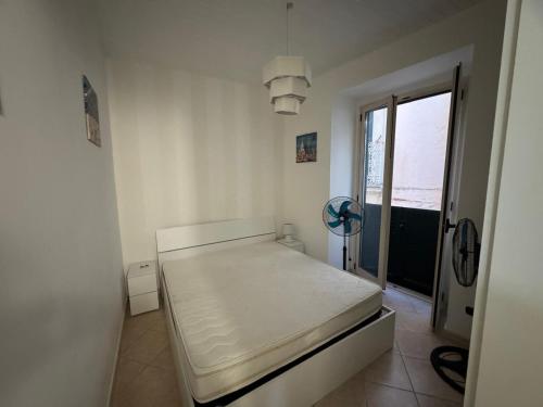 a white room with a bed and a window at rupea breeze home in Tropea