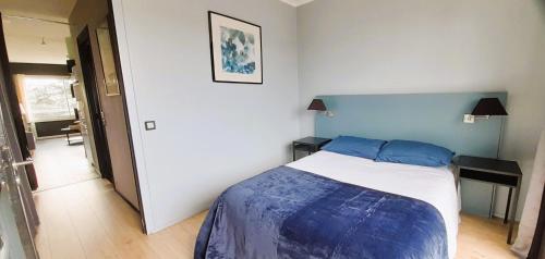 a bedroom with a bed with a blue head board at Type 2 Catho Esa in Angers