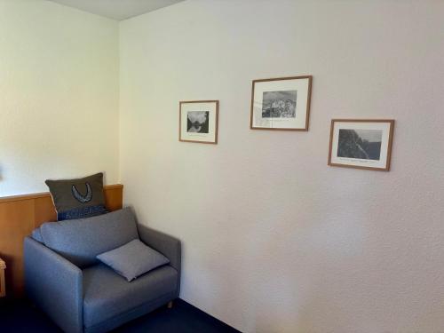 a room with a chair and three pictures on the wall at Aotearoa - Mountain apartment in Bavaria, Mitterdorf - Mitterfirmiansreut in Mitterfirmiansreut