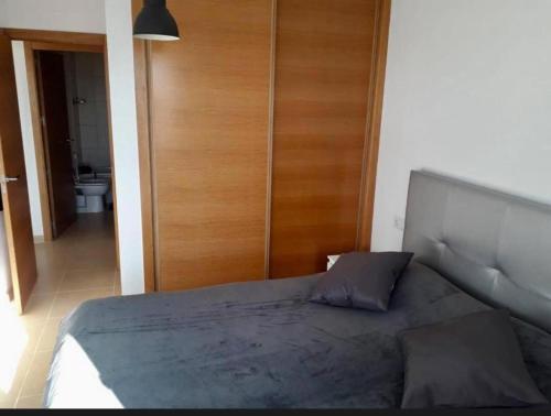 a bedroom with a bed and a wooden door at Torres in Roldán