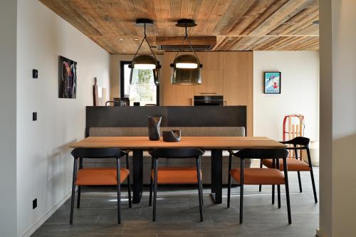 une salle à manger avec une table et des chaises en bois dans l'établissement Homency - Chalet White Stone Igloo, à L'Alpe-d'Huez