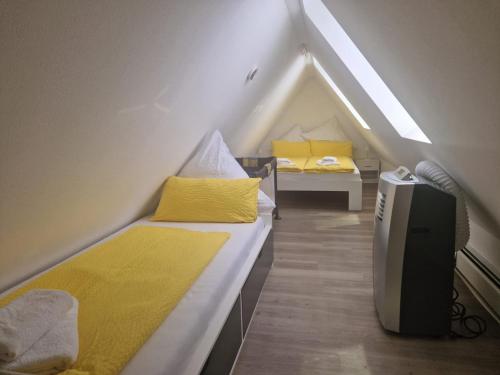 a attic room with two beds and a tv at Ferienwohnung in Schonwald im Schwarzwald