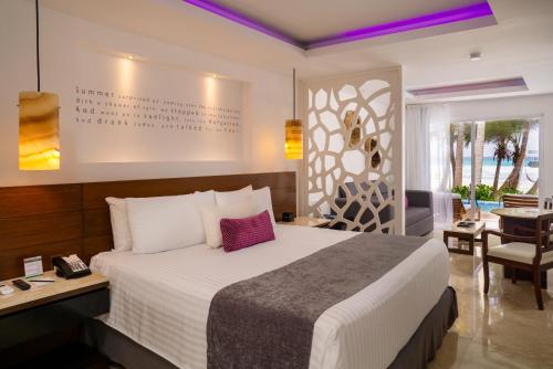 a hotel room with a bed and a table and chairs at Flamingo Cancun All Inclusive in Cancún