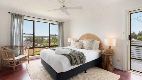 een slaapkamer met een bed en een groot raam bij Lakeview Retreat in Culburra Beach