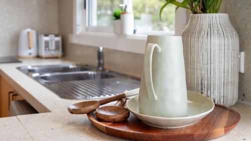 een aanrecht met een wastafel en een kom op een snijplank bij Lakeview Retreat in Culburra Beach