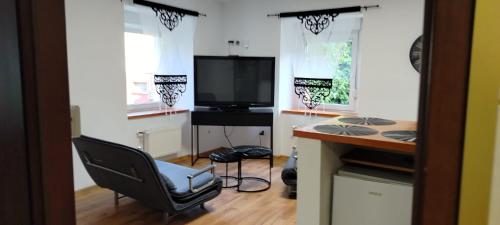 a room with a desk and a chair and a television at Apartament na Sienkiewicza in Leśna