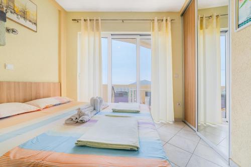 a bedroom with two beds and a large window at Apartment Dragicevic 5 with Garage in Budva