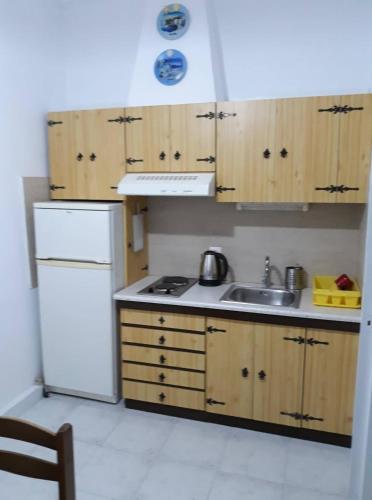 a kitchen with a white refrigerator and a sink at Anna-Maria in Nea Kalikratia