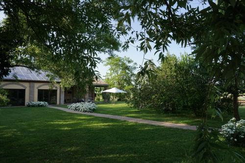 un giardino con una casa e un prato di Agriturismo L'Unicorno a Portomaggiore