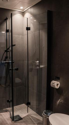a bathroom with a shower with a glass door at Hemsedal Cafe Skiers Lodge in Hemsedal