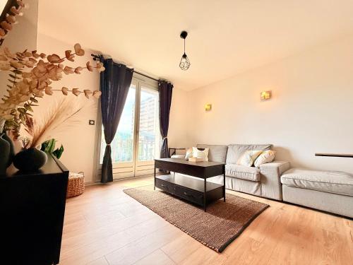 a living room with a couch and a table at Maison rénové 10 prsn Parking privée & Balcon Proche Gare-Viotte in Besançon