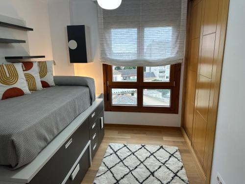 a bedroom with a bed with a dresser and a window at #Las Azaleas# in Ribadeo