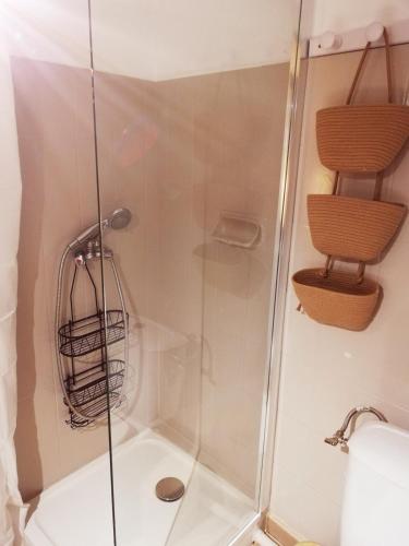 une douche avec une porte vitrée dans une salle de bain dans l'établissement Coquet T2 rénové, proche plages et Hyères, 4 couchages, à La Crau
