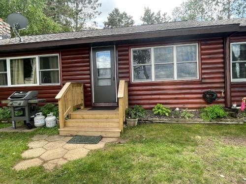 a wooden house with a porch and a door at Butler's Bay Cottage cottage in Hayward