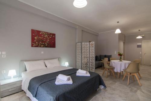 a bedroom with a bed and a table and chairs at Paxos In Square Studio Poseidon in Gaios
