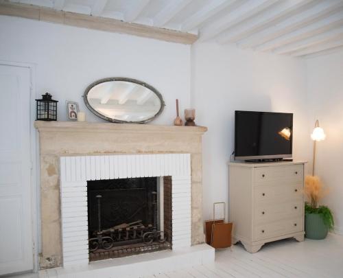 un salon avec une cheminée et un miroir dans l'établissement Charm and comfort, à La Celle-sous-Gouzon