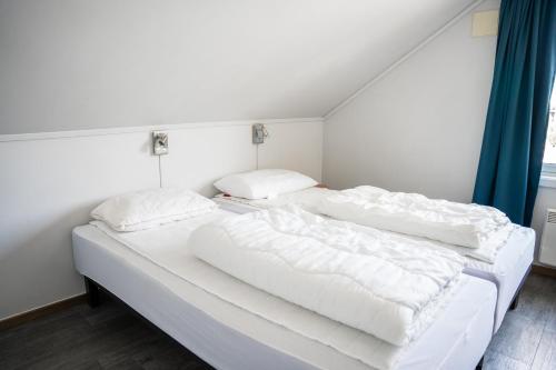 two beds in a room with white sheets and pillows at Hemsedal Cafe Skiers Lodge in Hemsedal
