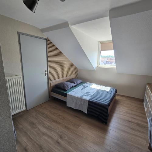 a bedroom with a bed and a window at Petit appartement 1 Le charmant in Sarreguemines