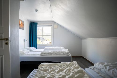 two beds in a room with a window at Hemsedal Cafe Skiers Lodge in Hemsedal