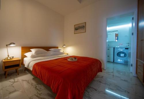 a bedroom with a bed with a red blanket at Opatija Rooftop Garden Oasis by the Beach ArtSpace in Opatija