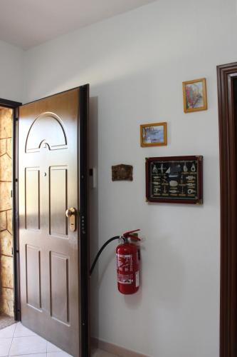 a door with a fire extinguisher on a wall at La Rosa dei Venti in Alghero