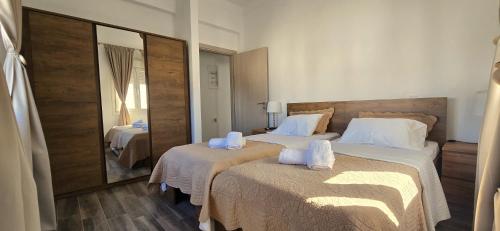 a hotel room with two beds and a mirror at Seaside Haven in Vari in Vari