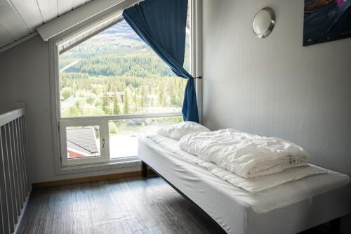 a bed in a room with a large window at Hemsedal Cafe Skiers Lodge in Hemsedal