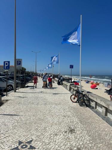 a beach with two blue flags and a bicycle on it at Beach Luxury Apartment in Praia de Mira