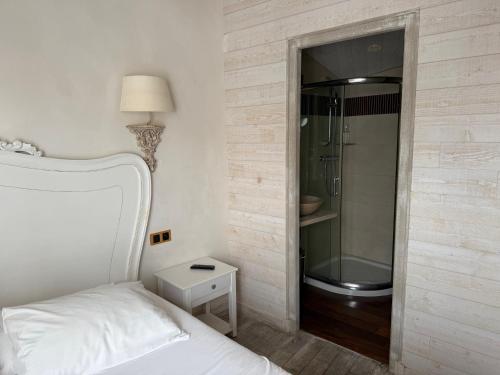 a bedroom with a bed and a walk in shower at Chambre d'hôtes Hôte des Portes Île de Ré in Les Portes