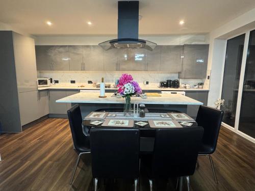 a kitchen with a table with a vase of flowers on it at Contemporary 2 bed house with Parking in West Thurrock