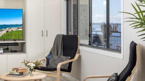 a room with a chair and a table and a window at Sandy Point Escape in Corlette