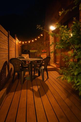 a table and chairs on a wooden deck at night at Gîte des fauvettes in Lorlanges