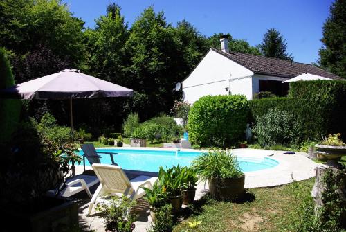 - une piscine avec 2 chaises et un parasol dans l'établissement vakantiewoning Thury, à Thury