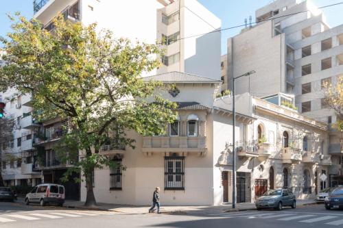 a person crossing a street in front of a building at Fliphaus Mansion Paz A 10 pax Deluxe House Belgrano in Buenos Aires