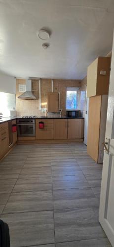 a large kitchen with wooden cabinets and a large floor at E13 x DM4 weekly monthly deals in London
