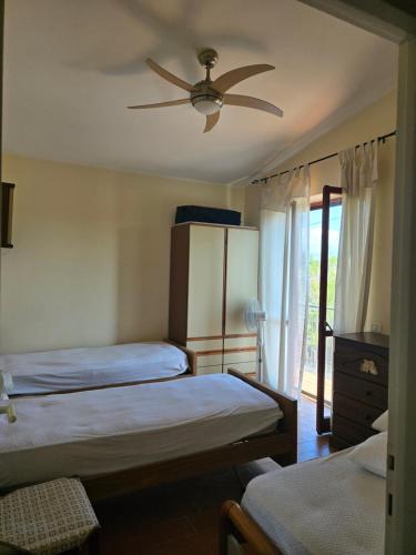 a bedroom with two beds and a ceiling fan at La casa al mare int2 in Lido Di Fondi