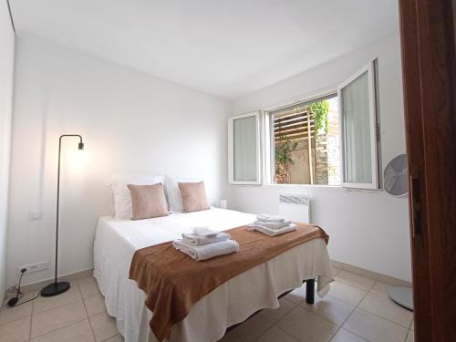 une chambre blanche avec un lit et une fenêtre dans l'établissement Charmant appart ,Proche de la plage, à San-Martino-di-Lota