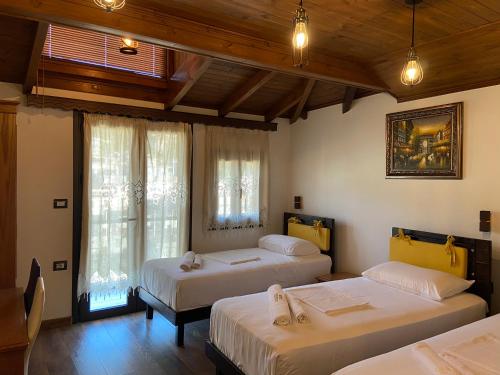 una camera da letto con due letti e una finestra di Hotel The First a Gjirokastër