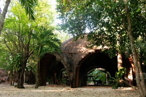an old building with an archway in a park with trees at Apartamento Flamingo - Santuario Apartments in Chemuyil