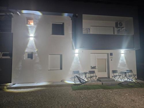 a white building with chairs and tables in front of it at ENA 1&2 -BIG FREE PRIVAT parking for BOATS, TRUCKs, combi,-CENTRAL HEATING !!! in Karlovac