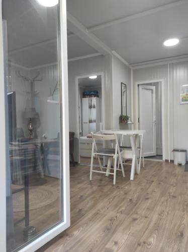 a living room with a white table and a dining room at Apartman sa sopstvenim dvoristem , pored mora in Bigovo