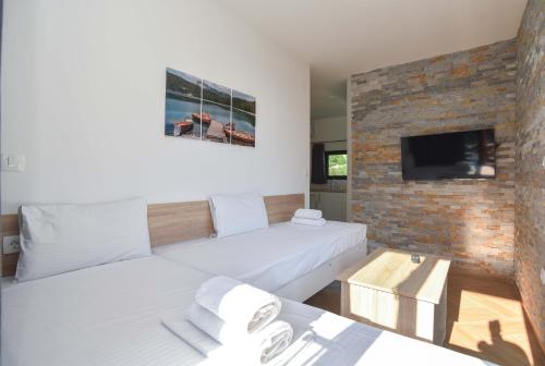 a living room with a white couch and a brick wall at Apartments A Čanj in Čanj