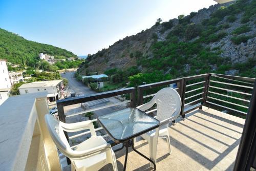 a balcony with a table and chairs and a mountain at Apartments A Čanj in Čanj