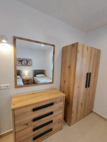 a bedroom with a wooden dresser and a mirror at Villa Eleni Apartment no2 in Agios Gordios